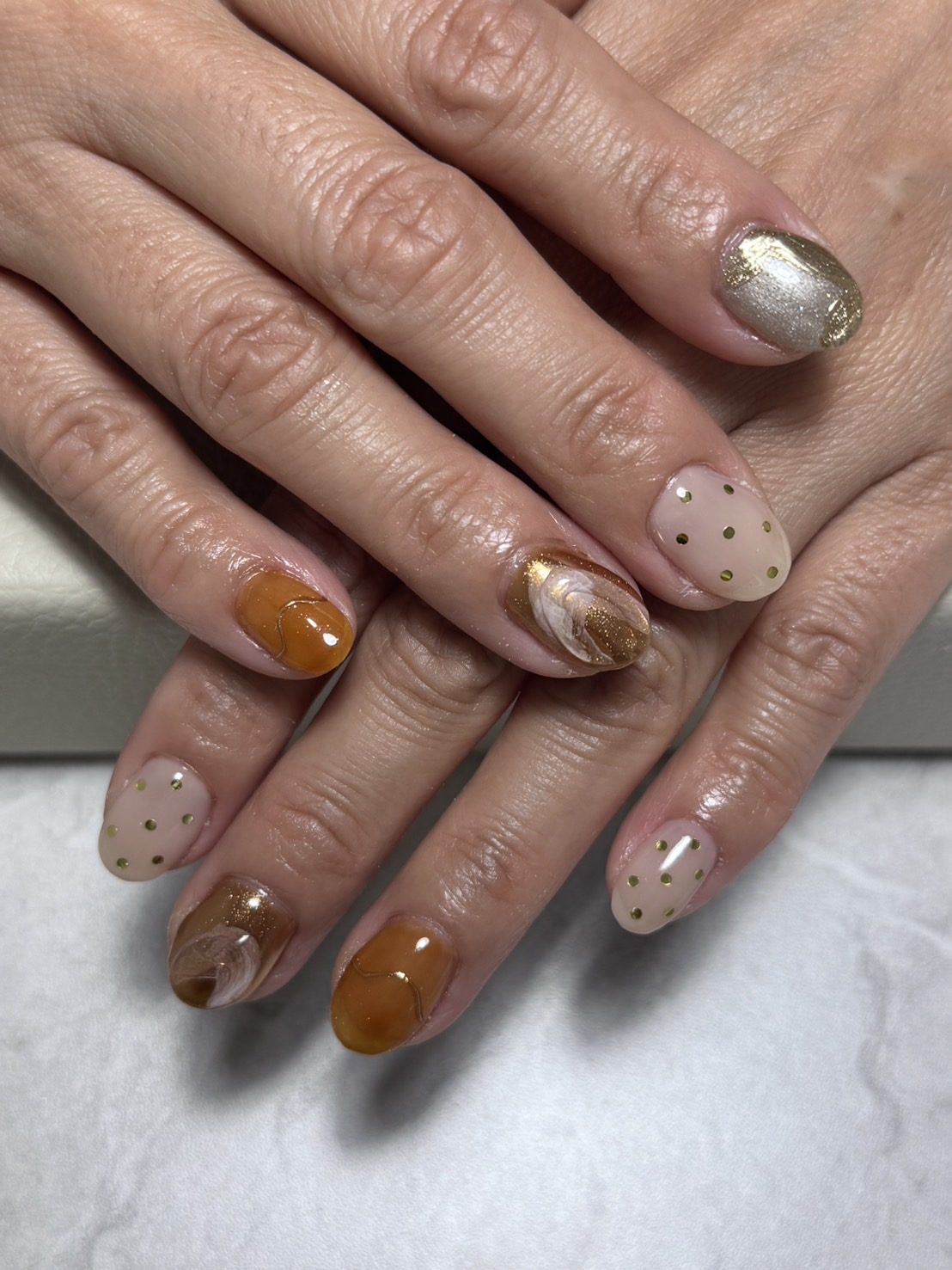 生徒がモデルに施術したブラウンとゴールドのネイル